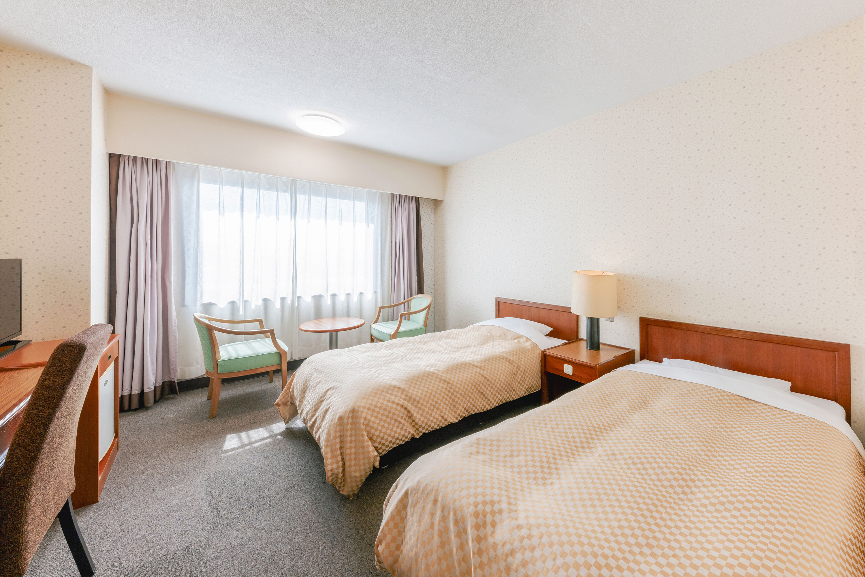 昼間の日差しが差し込む、熊本県八代グランドホテルのツインルーム。