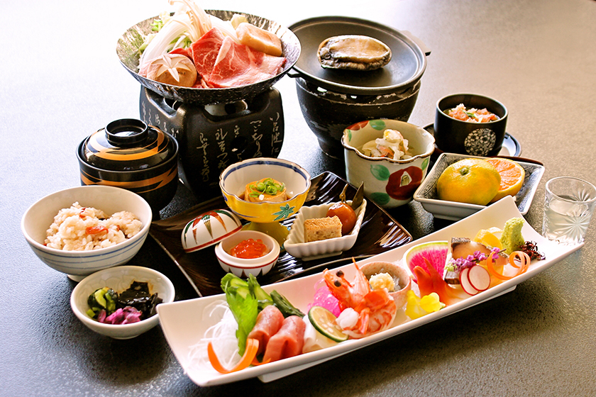 伊豆・畑毛温泉大仙家で提供される夕食「華やぎ会席」。活き鮑の踊り焼き・鮮魚六種盛り・牛ロースすき鍋など。11品の会席料理