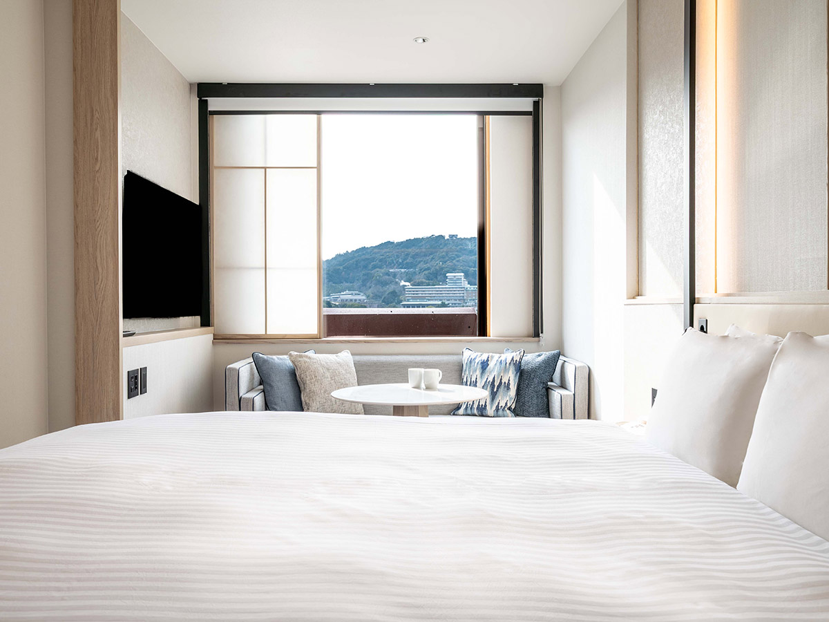 新客室キングルームのベッドと窓とソファー