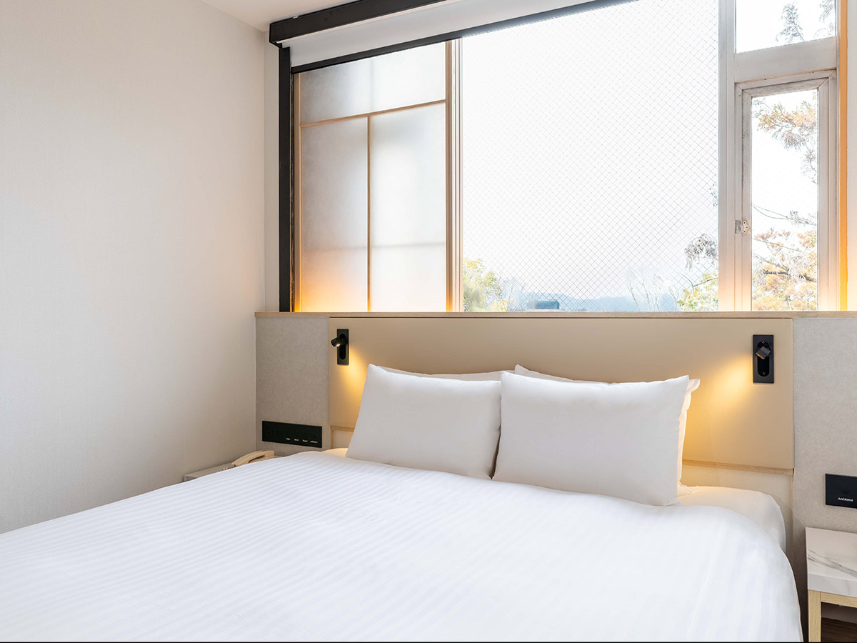 新客室クイーンルームのベッドと窓