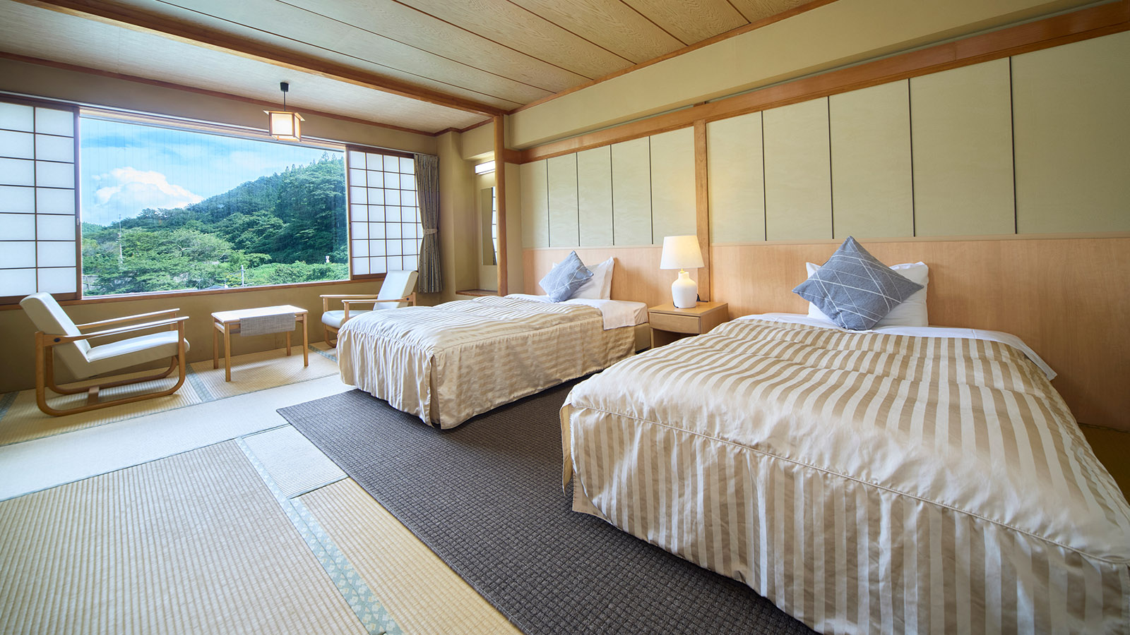 鳴子温泉ホテル亀屋の西館・和室ツイン10畳の客室。ツインベッドと広縁、窓から望む景色