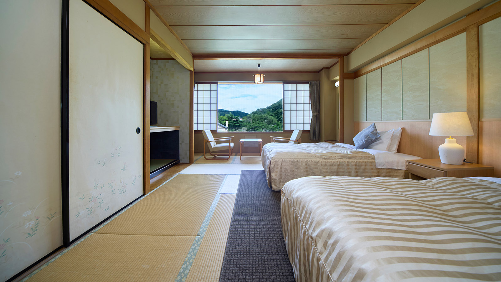 西館・和室ツイン10畳の客室。右側に設置されたツインベッドと、部屋の正面奥にある広縁