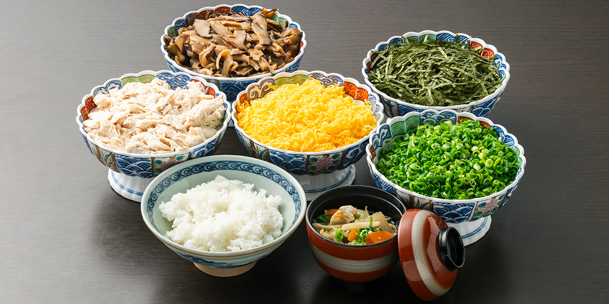 具材がたくさん入った薩摩汁と鶏飯のための鶏肉や錦糸卵などの具材とご飯