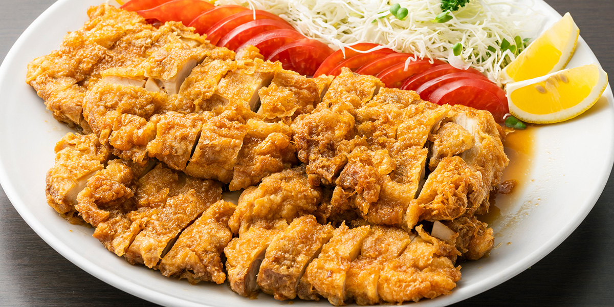こんがりとした色に揚がった鶏肉と野菜のつけあわせのチキン南蛮